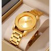 Reloj de cuarzo dorado con esfera redonda y pulsera de eslabones, exhibido dentro de una caja de color claro.