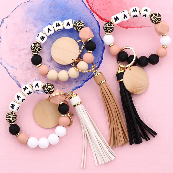 Set aus Leopardenmuster-Silikonperlen-Anhänger in pink, schwarz und weiß auf rosa Hintergrund.