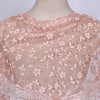 A sheer pink floral lace scarf draped over a mannequin's neck.