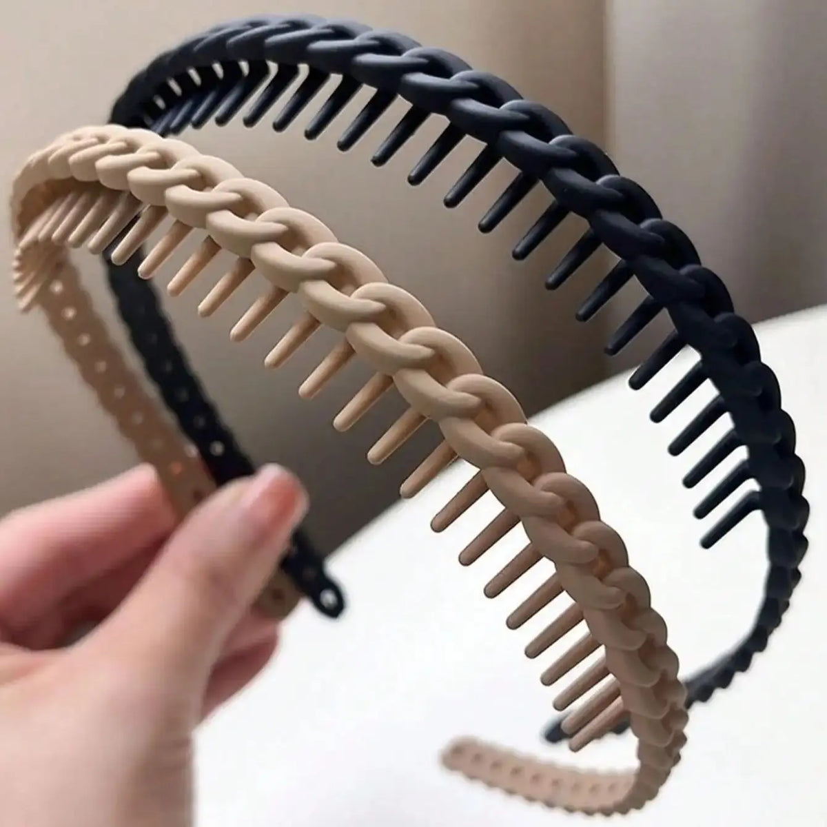 Deux bandeaux pour cheveux, un noir et un beige, montrant un design antidérapant à dents givrées.
