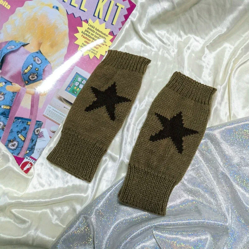 Un par de guantes sin dedos de punto verde oliva oscuro con diseño de estrella negra, mostrados sobre un fondo blanco sedoso.