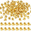 A pile of small gold-colored jewelry findings stoppers or spacers for connectors.