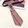 A pink bow tie with a silver crystal rhinestone clasp tied to a black ribbon.