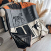 A luxury plaid cashmere feel scarf and shawl wrap featuring black, gray, and orange patterns with horse motifs.