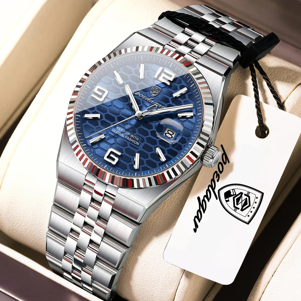 A silver and blue luxury quartz wristwatch with a metal bracelet and leather strap is displayed in a light-colored box.