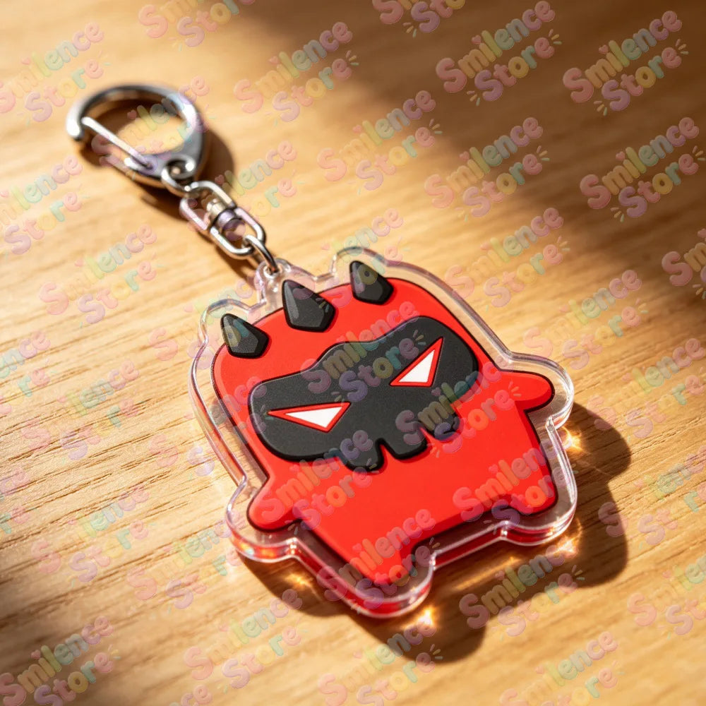 A red and black stylized monster keychain featuring sharp horns and a fierce face on a clear plastic background.