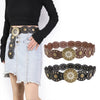 A woman models a retro western cowboy round hollow metal belt with decorative studs and leather accents.