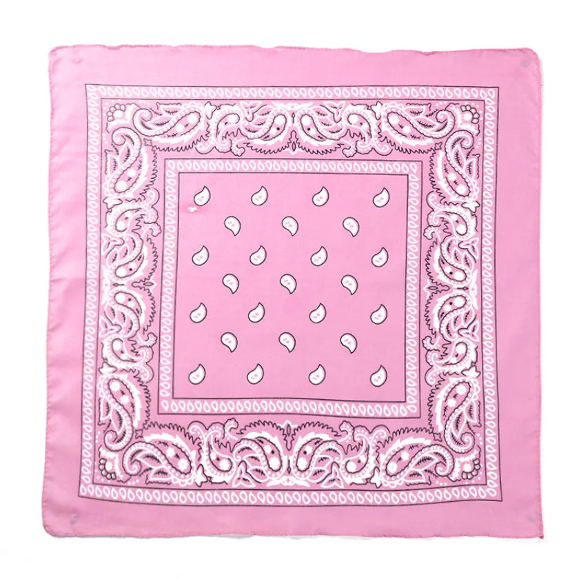 Cuadrado de tela rosa bordado con un borde decorativo y pequeñas formas de cachemir blanco.