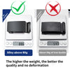 A black alloy iron buckle shown next to a digital scale, demonstrating its weight and quality.
