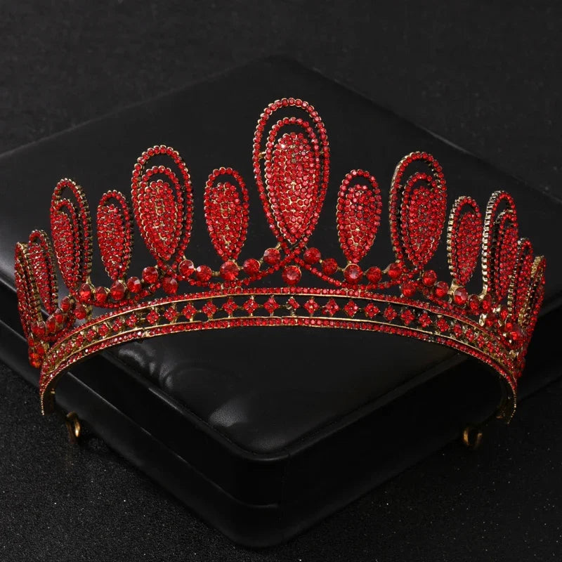Tiare et couronne en strass de cristal rouge, présentés sur une boîte en velours noir.