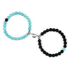 A pair of natural stone heart couple bracelets, one turquoise and one black, displayed against a white background.