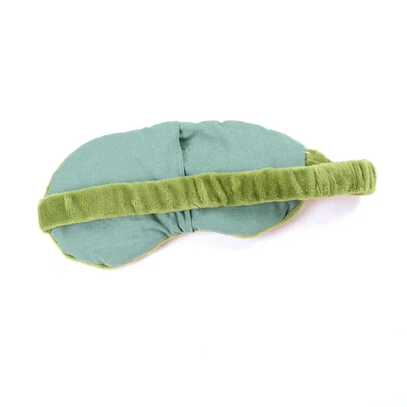 A soft sage green cotton sleep mask with a contrasting olive green strap.