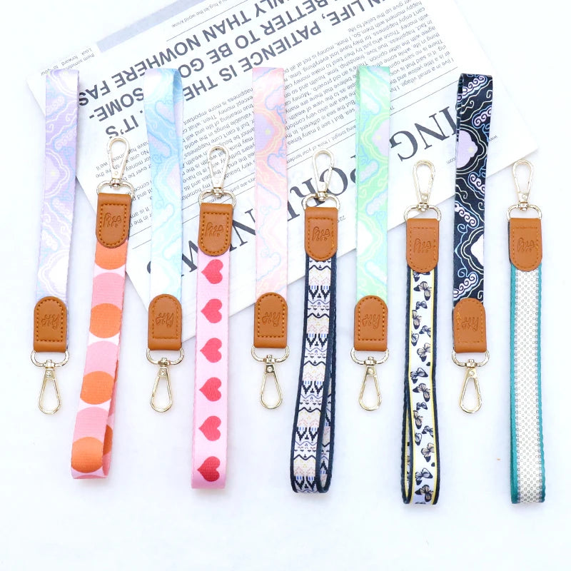 Eine Kollektion von hochwertigen Leder-Handphone-Lanyards und Schlüsselbändern in verschiedenen Mustern und Farben.