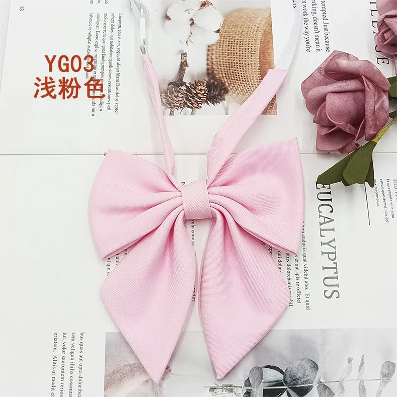 Pink solid cotton bow tie tied in a bow shape displayed on a white background.