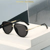 A pair of black aviator-style sunglasses with gold accents resting on a white surface.