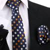Nahaufnahme einer eleganten Herrenkrawatte in marineblauer Farbe mit goldenen und weißen Polkadotierungen, gezeigt vor einem 
