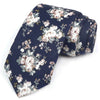 Une cravate bleu foncé avec un motif floral élégant de roses blanches et de roses roses pâles et de verdure.