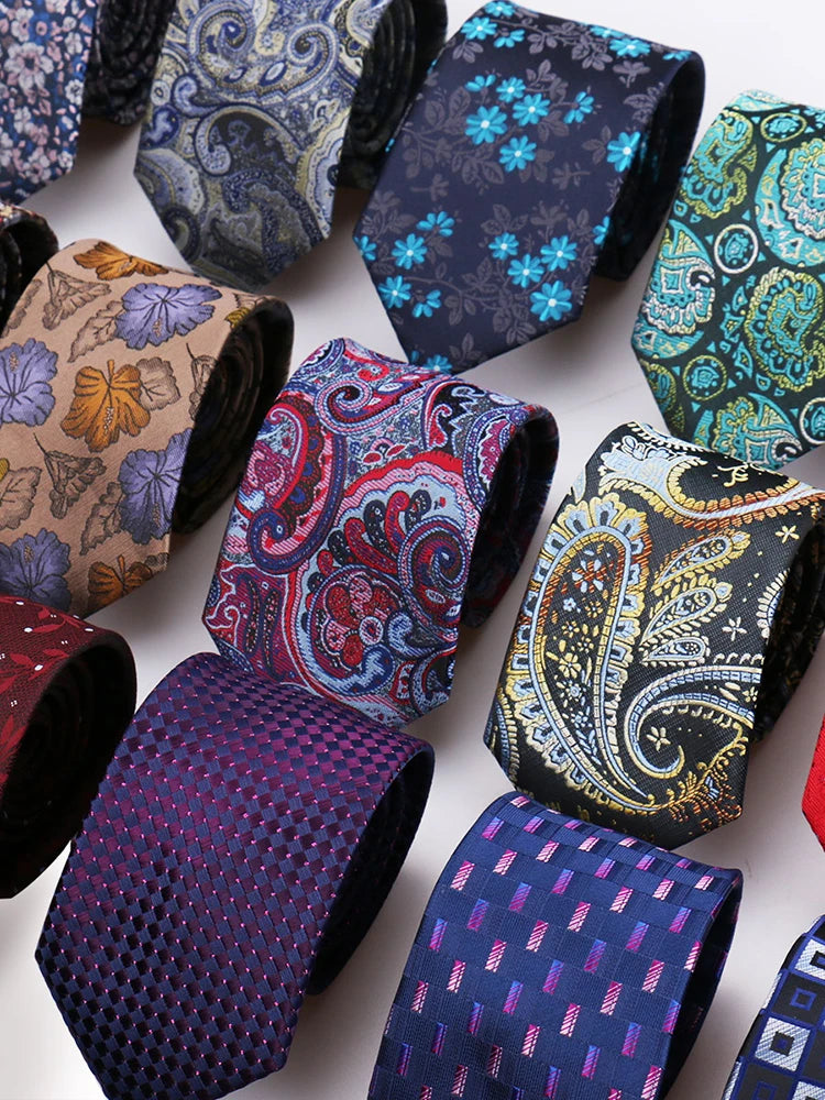 A collection of six patterned men's formal ties and accessories in various floral and geometric designs.