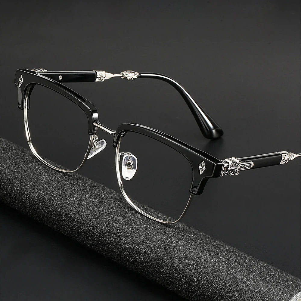 Une paire de lunettes noires avec des détails argentés posée sur une surface sombre.