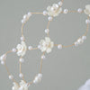 Elegant pearl hair net headband featuring small white flowers and delicate gold wire.