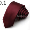 A dark burgundy satin neck tie folded and displayed on a white background.
