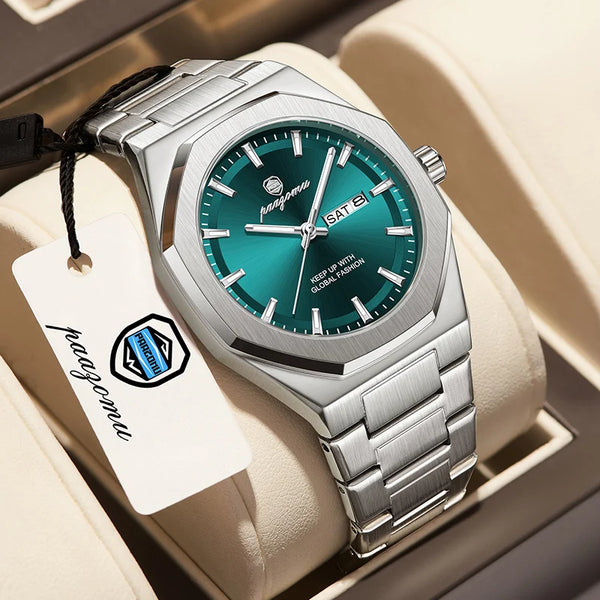 A silver stainless steel watch with a teal dial and a black strap is displayed in a light-colored box.