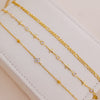 A set of gold-colored handmade crystal cross anklets displayed on a white surface.