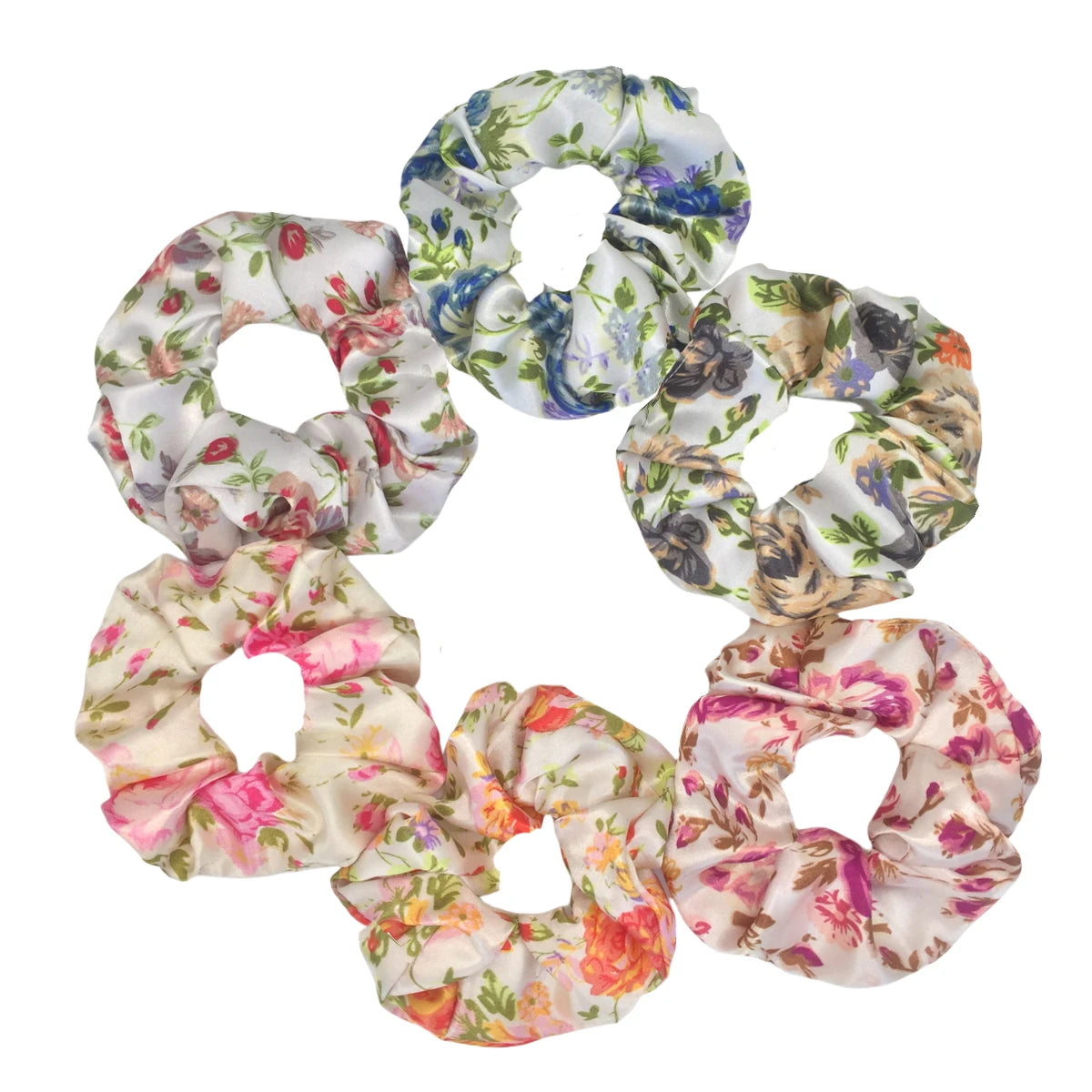 Un set de seis gomas para el pelo con estampado floral de satén en varios tonos de rosa, azul y verde.