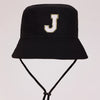 Black sun hat with a gold letter J embroidered on the front and an adjustable cord.