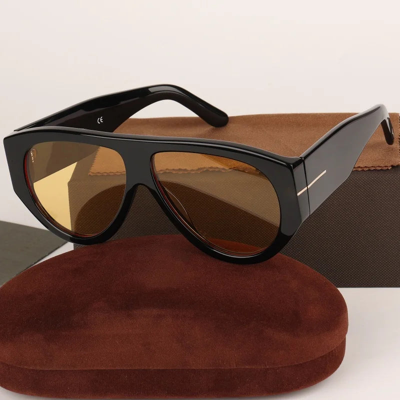 Black oversized pilot sunglasses resting on a brown suede box.