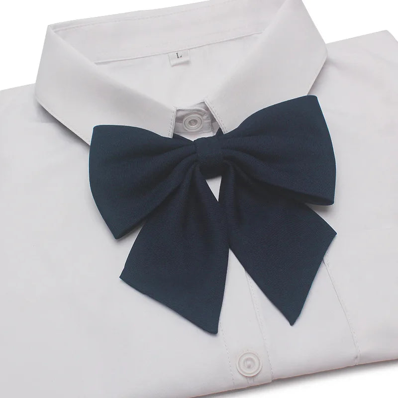 White dress shirt with a navy blue butterfly ribbon tie neatly tied at the collar