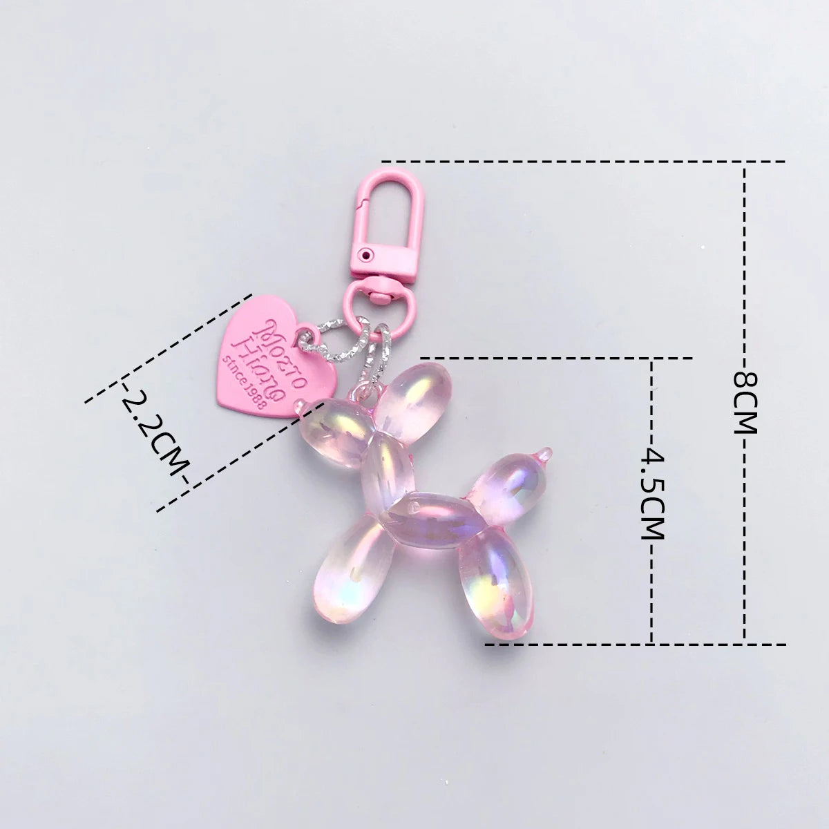 A pink resin animal dog keychain with a heart charm and a silver clasp.