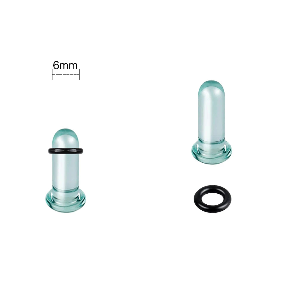 A clear glass ear stretching plug with a black ring and a measuring scale.