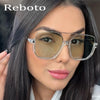 A woman models double bridge oversized square sunglasses with a silver frame and tinted lenses.
