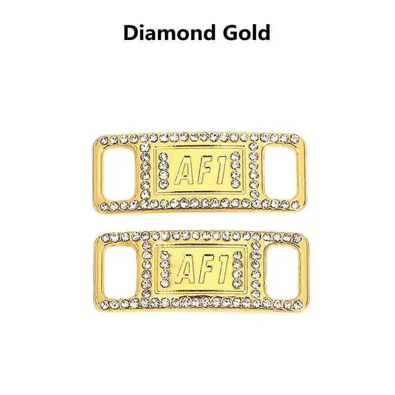 A pair of gold diamond shoe charms and laces labeled AF1