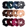 A set of six velvet scrunchies in various shades including dark green, navy blue, gray, brown, and pink.