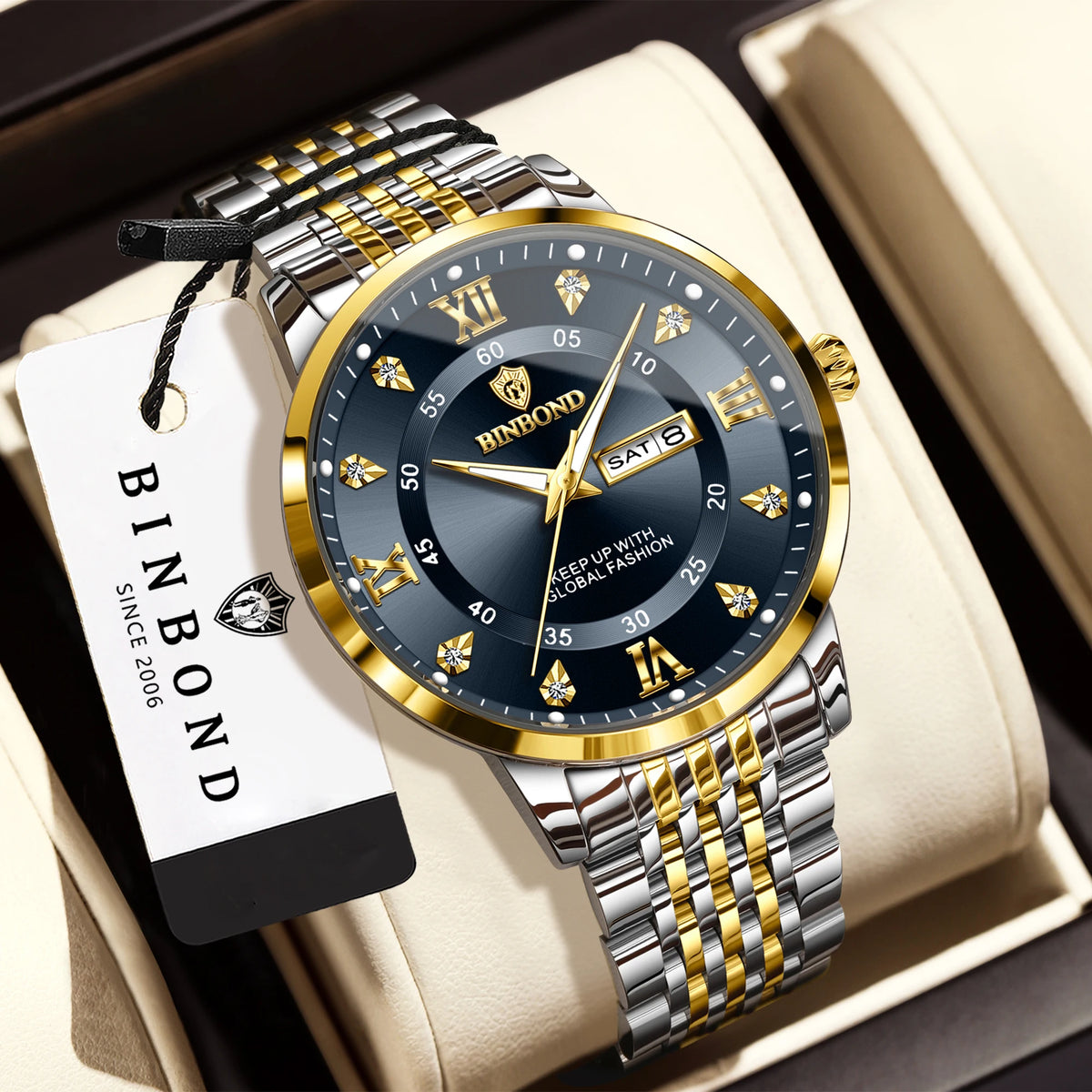 A silver and gold watch with a black dial and gold accents is displayed in a light-colored box.