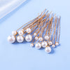 A collection of 18 faux pearl hair pins with thin metal wires arranged diagonally on a light blue background.