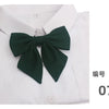 A white collared shirt with a dark green butterfly ribbon tie set on the chest.