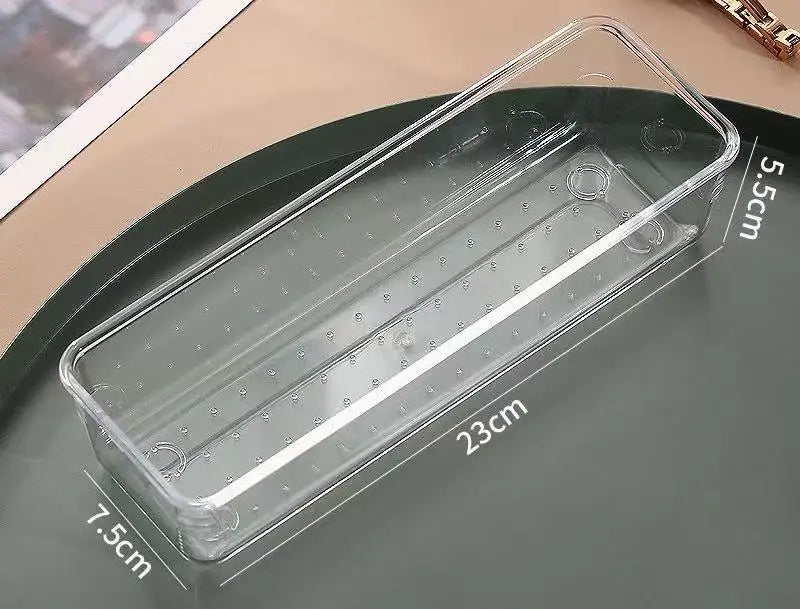 A clear plastic jewelry storage pouch with measurements and a gold bracelet shown on a dark surface.
