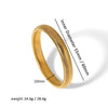 A close-up view of a gold-toned elastic bangle bracelet with a textured surface and a measurement guide.