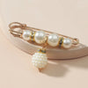 Gold-toned adjustable pearl brooch featuring round pearls and a cluster of small pearls