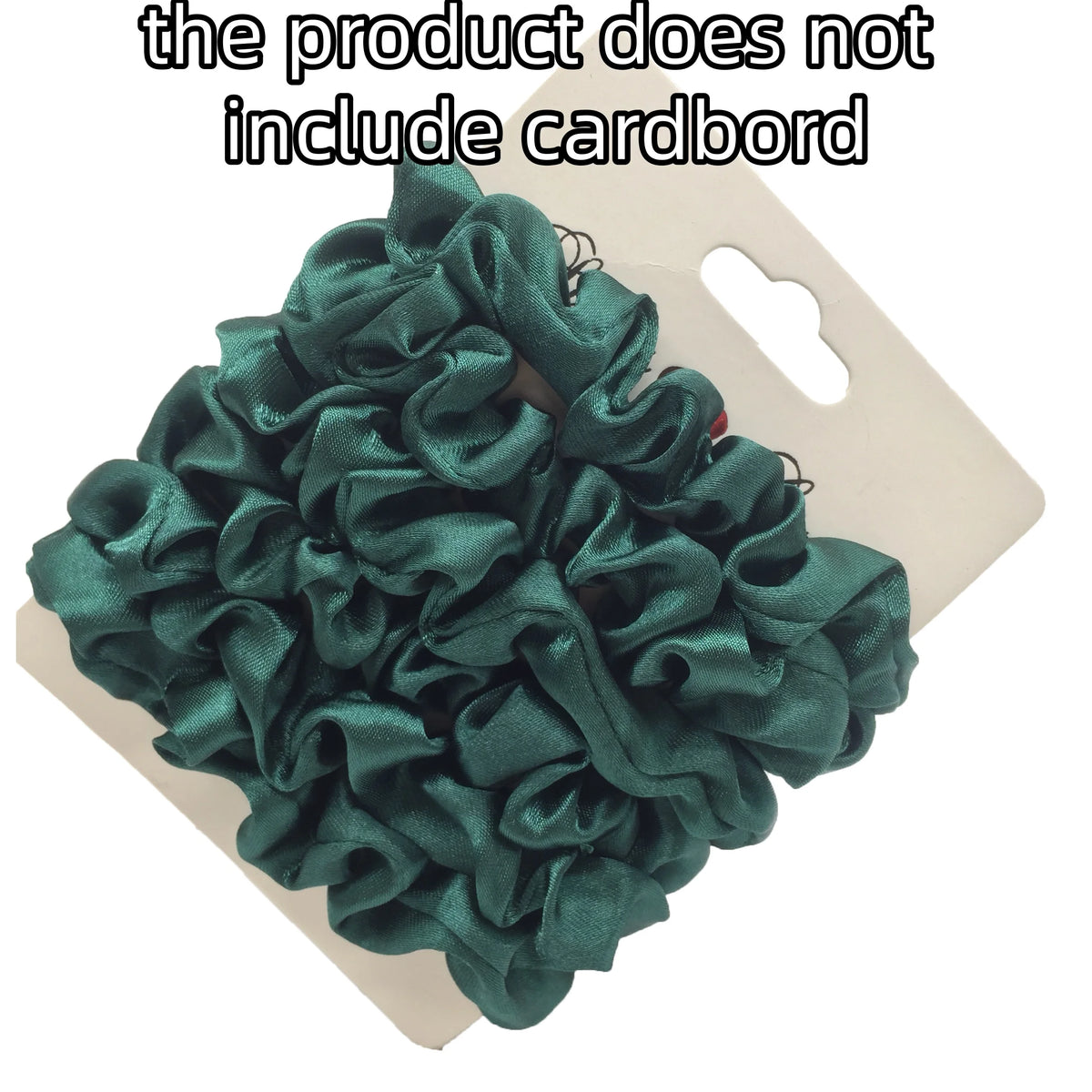 A pile of dark emerald green satin hair scrunchies is displayed on a white cardboard background.