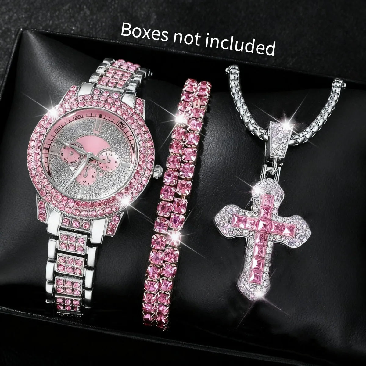 A set of three pink and silver diamond rhinestone jewelry pieces including a watch, bracelet, and cross pendant.