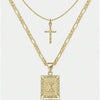 Collier pendentif lettre X et croix dorés sur fond blanc