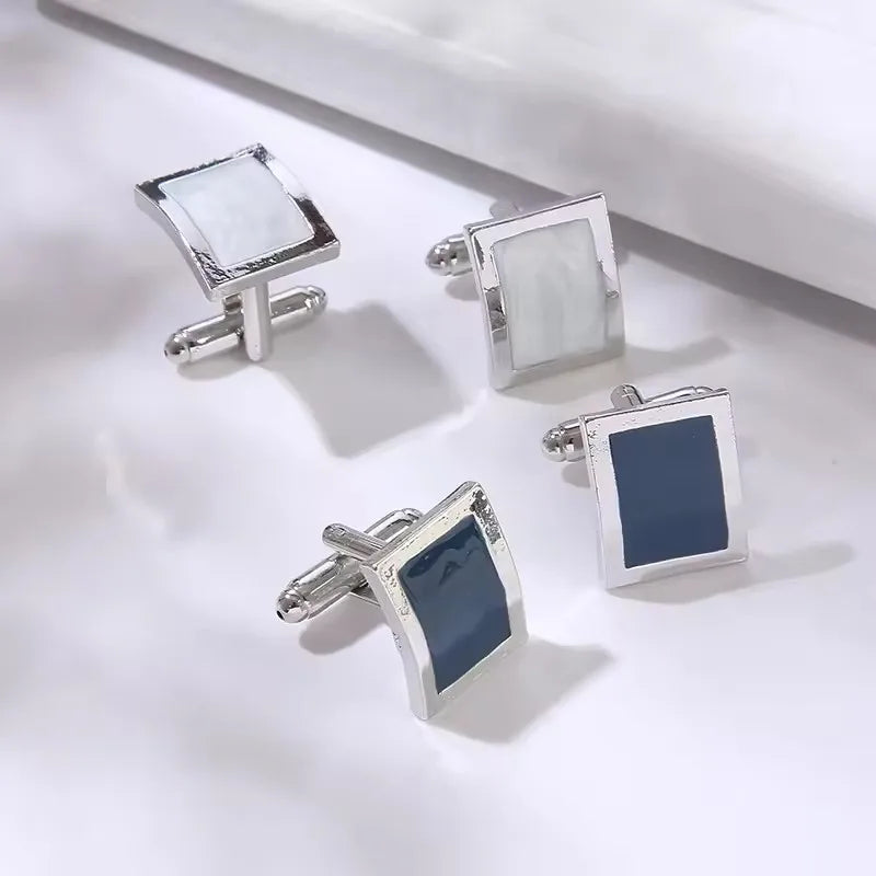 Pince-cuffs carrés argentés avec une pierre bleue rayée rectangulaire et une pierre blanche transparente.