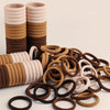 A stack of beige and brown elastic hair ties for ponytails and buns.