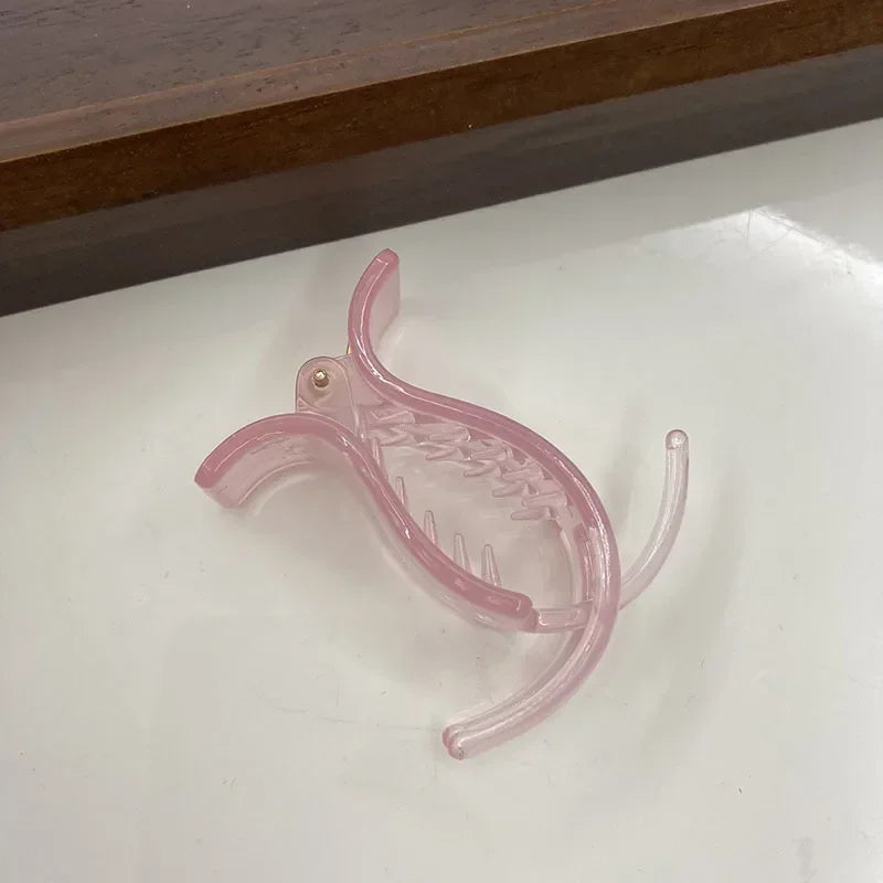 A clear pink acrylic hair claw designed for styling ponytails and hair.
