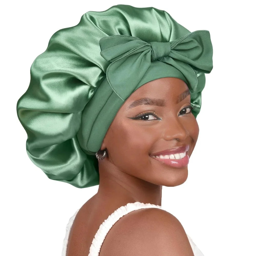 A woman wearing a satin green sleeping bonnet tied in a bow