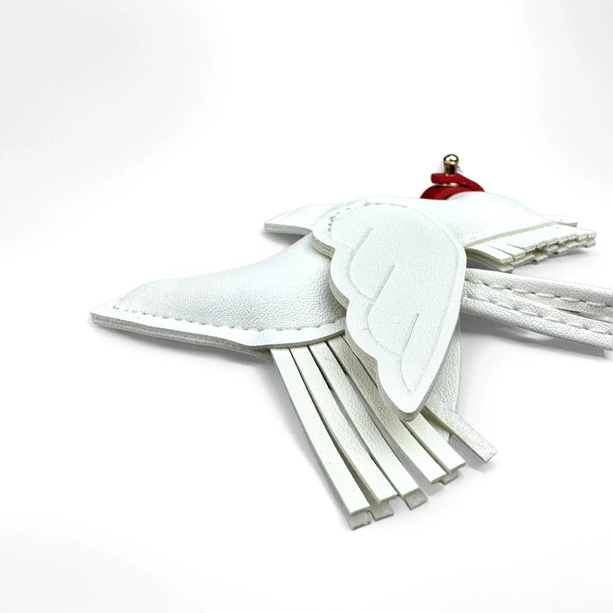 A white leather winged pony keychain with a red accent.